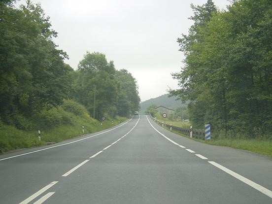 Una carretera con arboles de fondoDescripción generada automáticamente