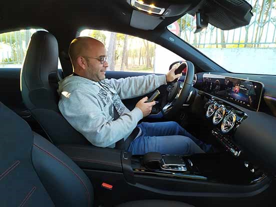 Un hombre sentado en el asiento trasero de un cocheDescripción generada automáticamente con confianza media